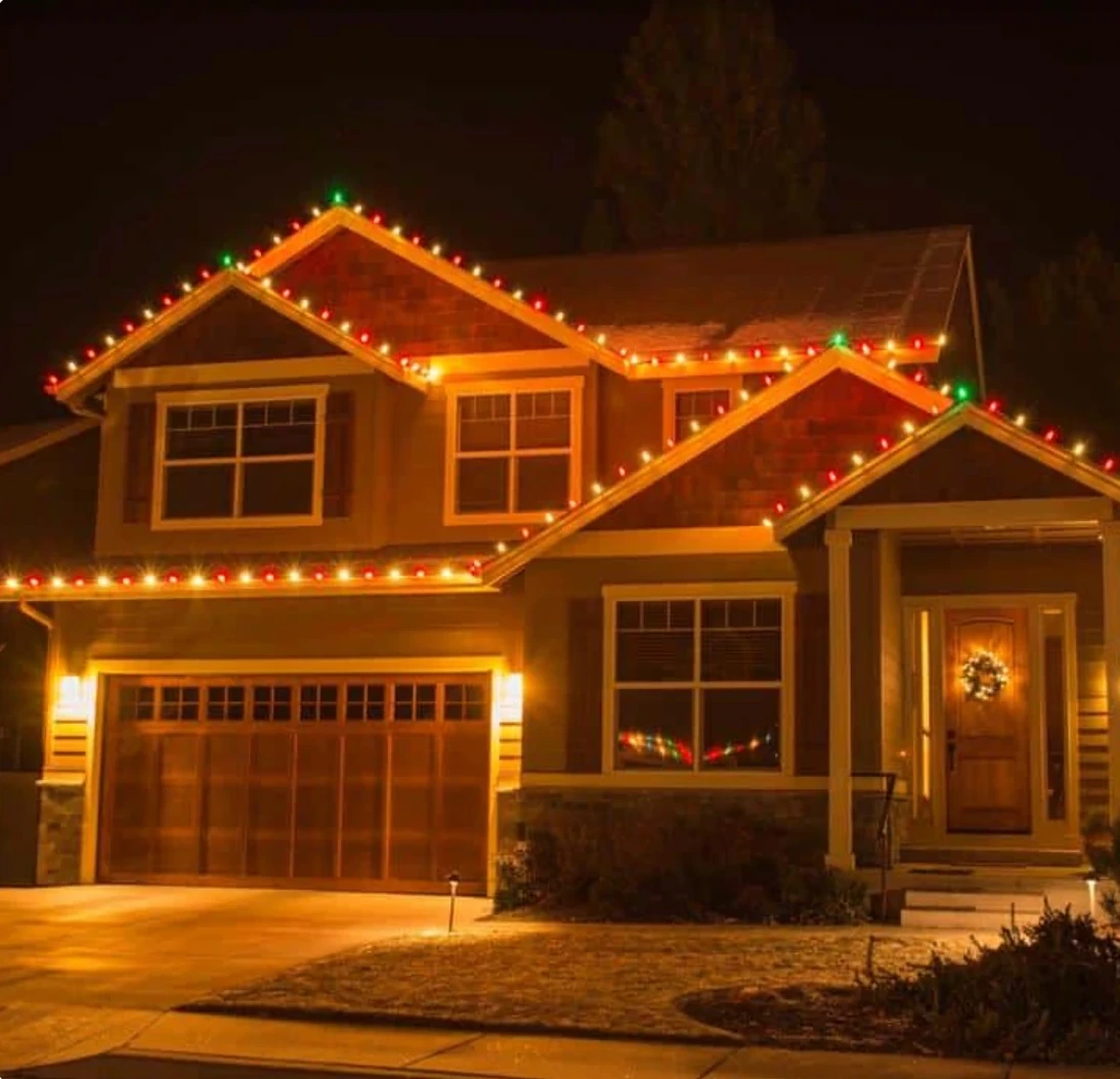 A home decorated with glowing warm and colorful Christmas lights, photographed on Backyard Paradiso's holiday lighting page