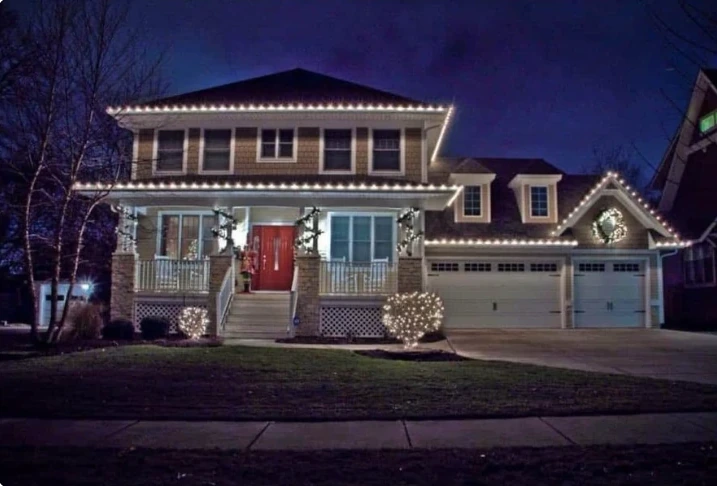 Two-story house with bright white holiday roofline lighting